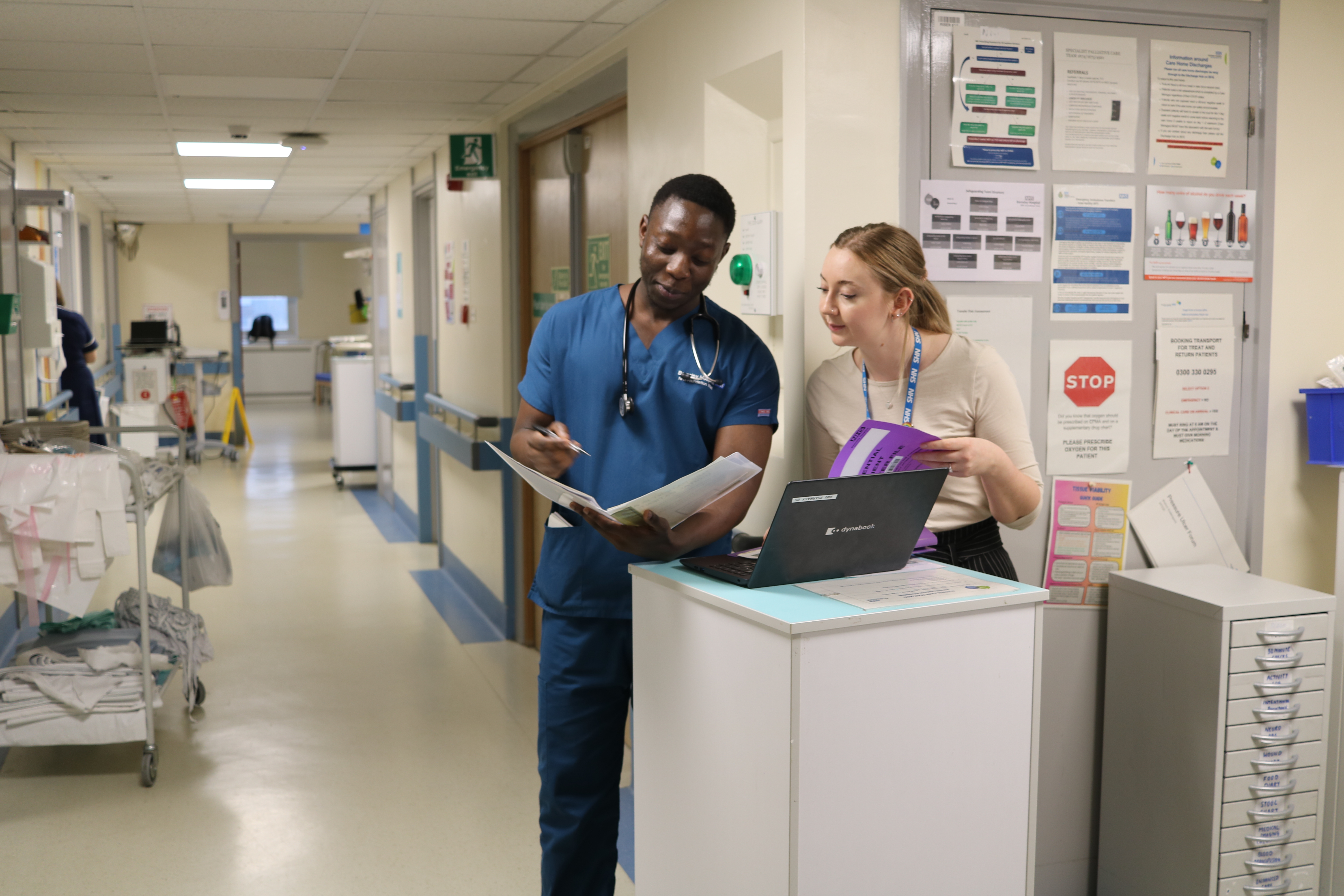 Colleagues review a document on a ward