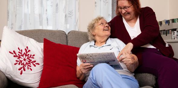 An older same-sex couple read together.