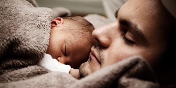 Father holds sleeping baby on his chest