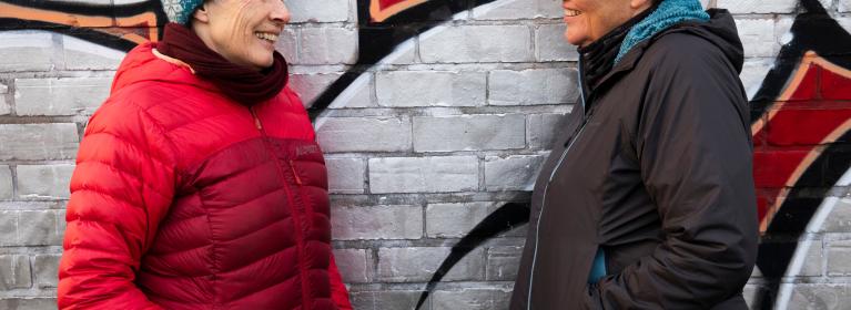 Two women smile and chat together