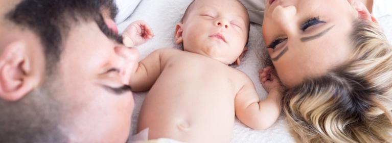 Parents on bed with baby