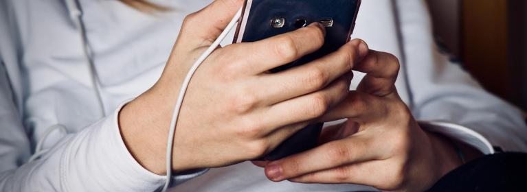 A woman using a smartphone with headphones