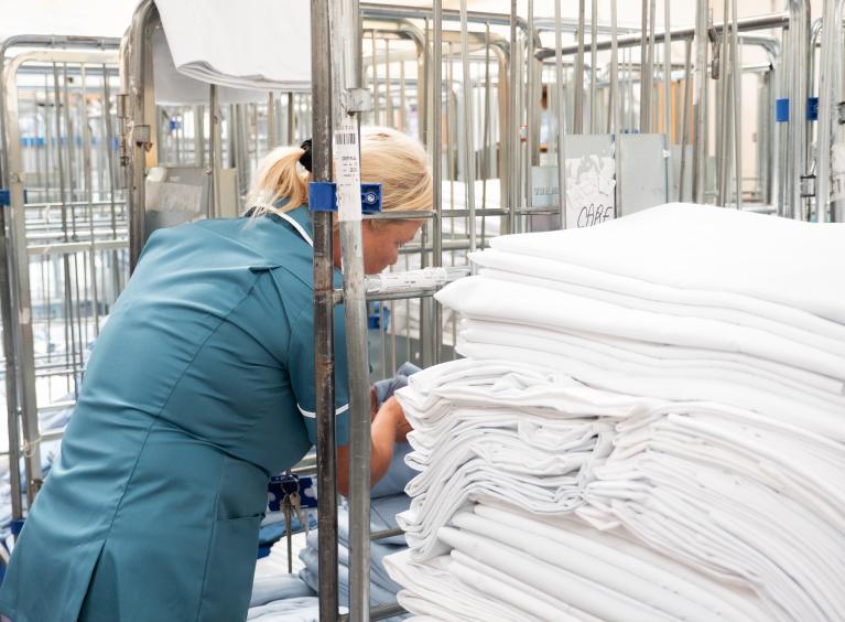 A member of our domestic team picks up some clean laundry
