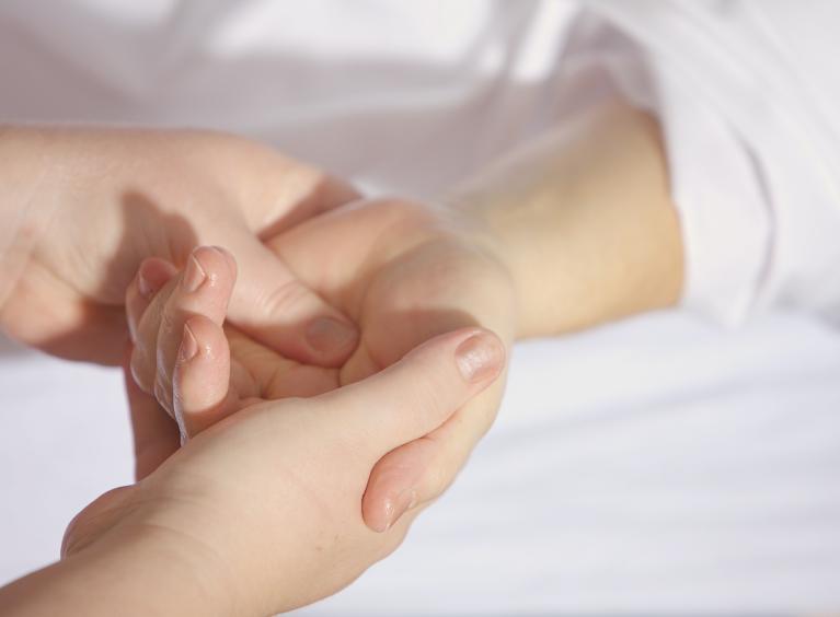 A physiotherapist at work - carrying out a hand massage with a patient - close up of two hands. 
