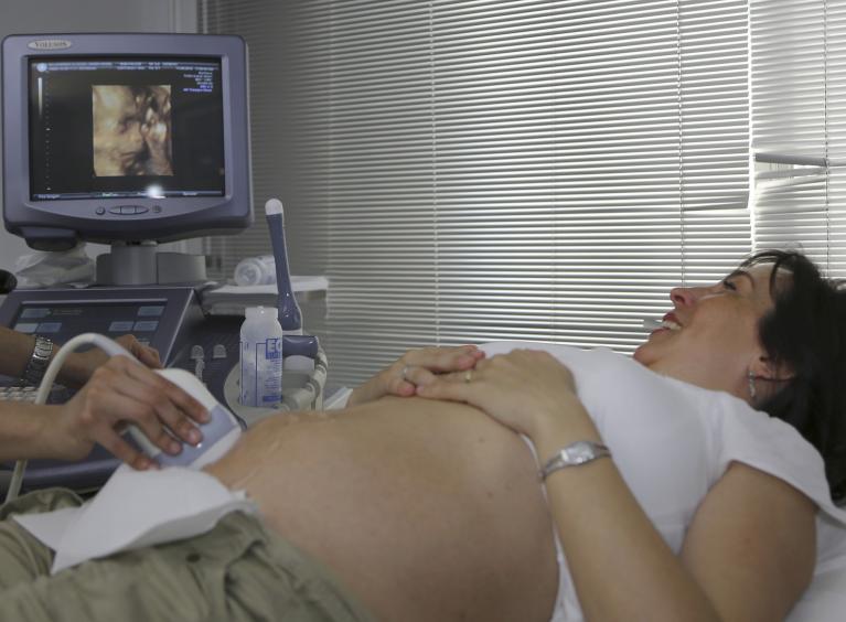A pregnant person having an ultrasound.