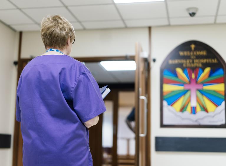 A member of staff stands outside the entrance to Barnsley Hospital's Chapel.
