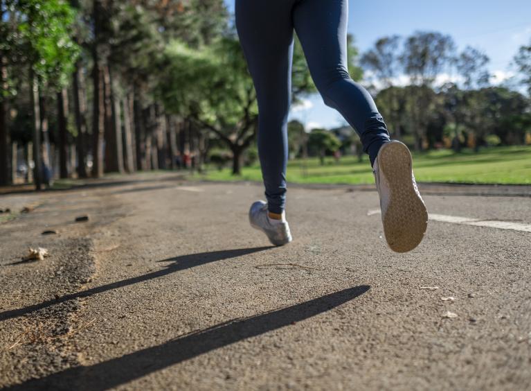 A woman runs through a park