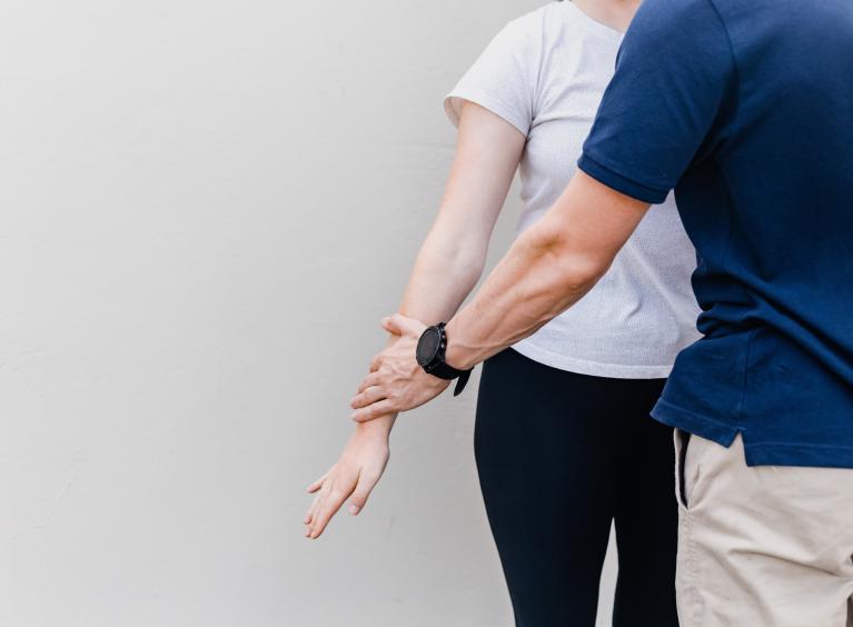 A physiotherapist assists a patient. 