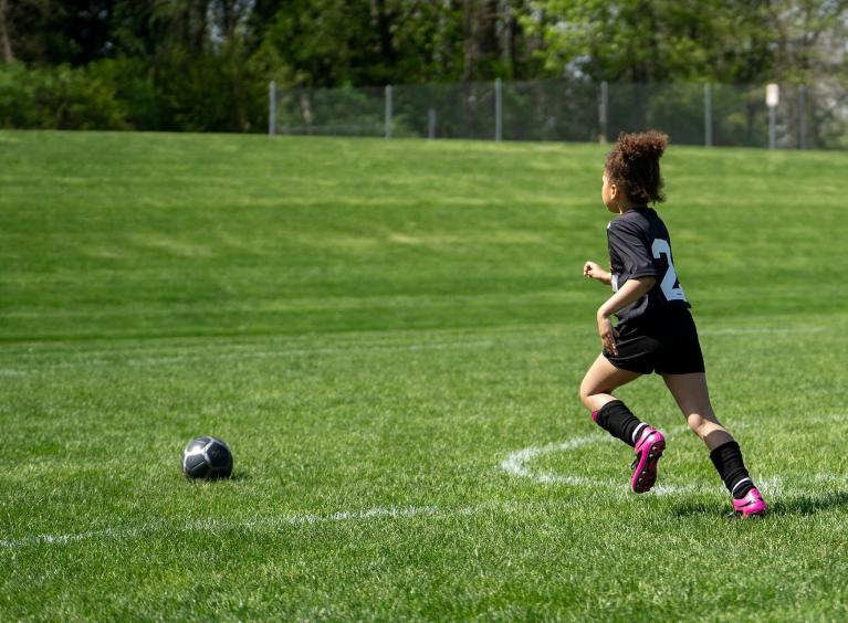 A child of around age 8 to 10, playing football.