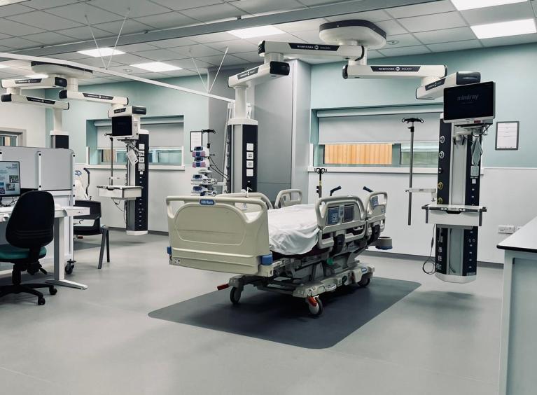 An intensive care bed is surrounded by equipment