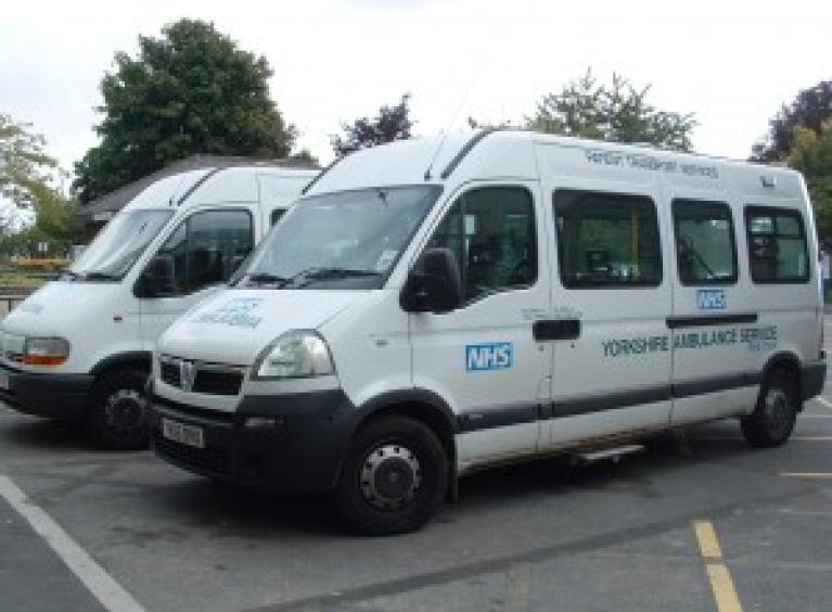 Two white mini-buses used for patient transport, to and from Barnsley Hospital - the NHS logo and Yorkshire Ambulance Service is written on the buses.