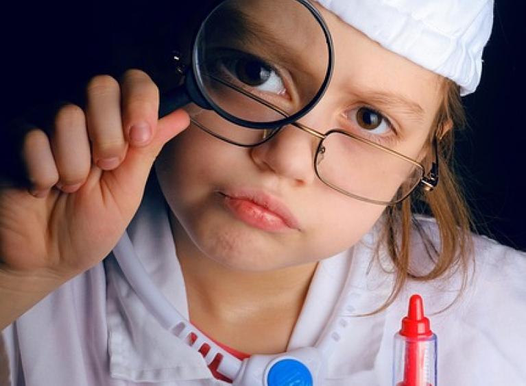young girl dress as a doctor whilst holding a injection