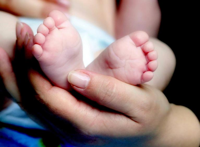 A baby's feet held in an adult's hands