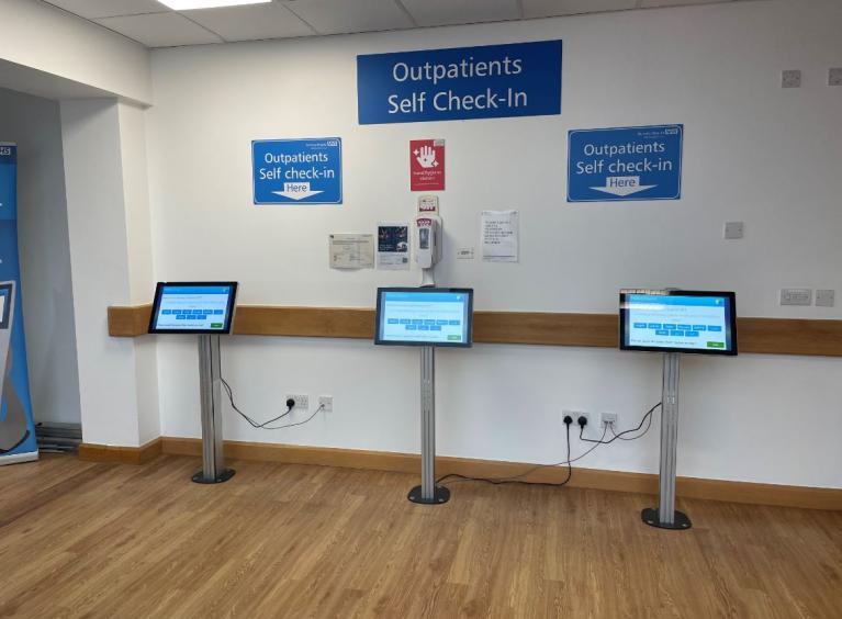 Three self-check-in kiosks in the reception of outpatients