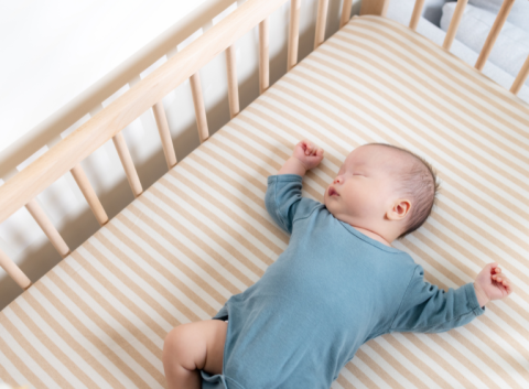 Baby in a cot sleeping on their back