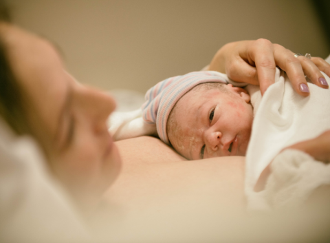 Mother holding a newborn baby on their chest