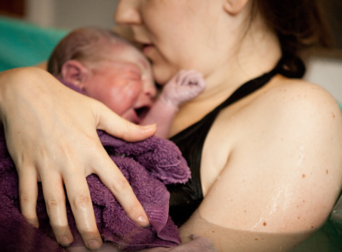 Mother holding baby following a waterbirth