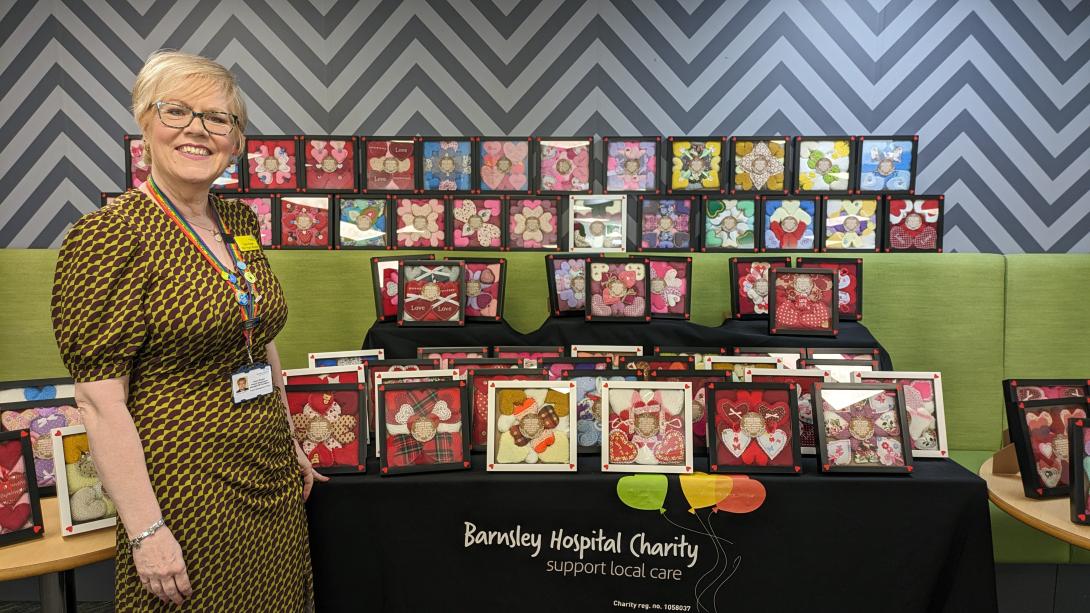 Sue Burgan with a selection of framed knitted hearts on display